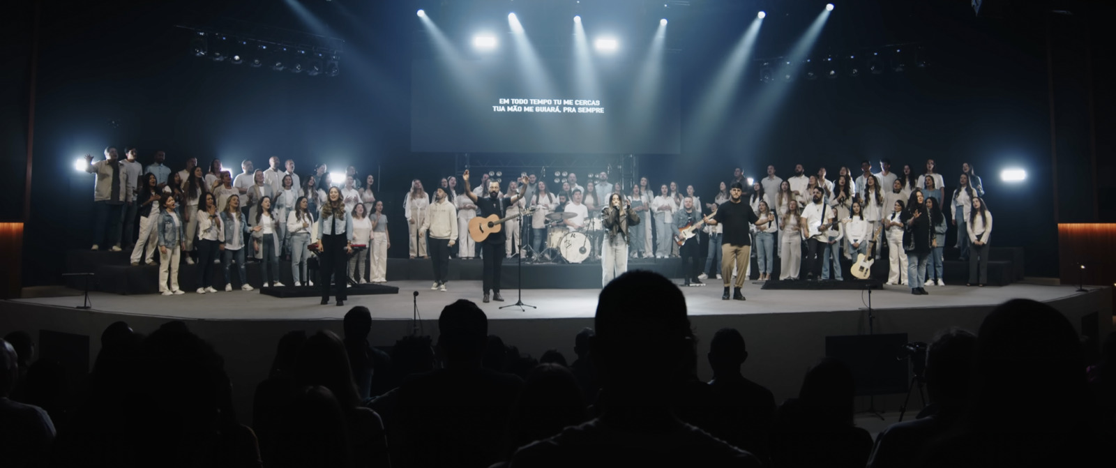 Banda e coral conduzindo a adoração na celebração de domingo